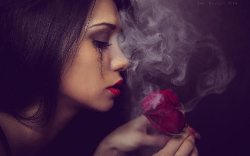 一个女孩看着一朵抽烟的玫瑰