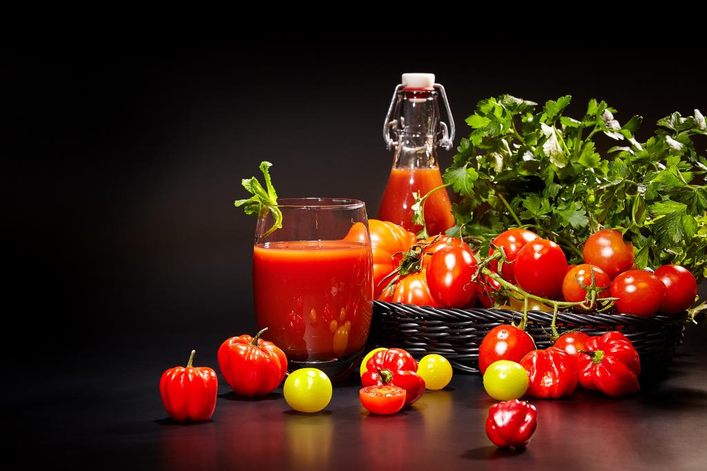 番茄汁和新鲜的西红柿，在黑色的背景上的桌子上