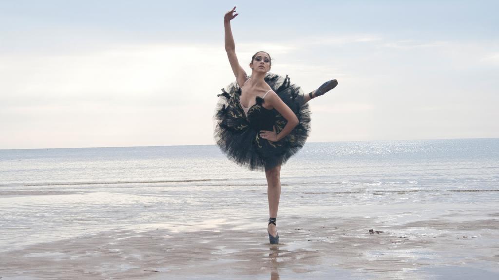 黑色的芭蕾舞女演员在海滩上