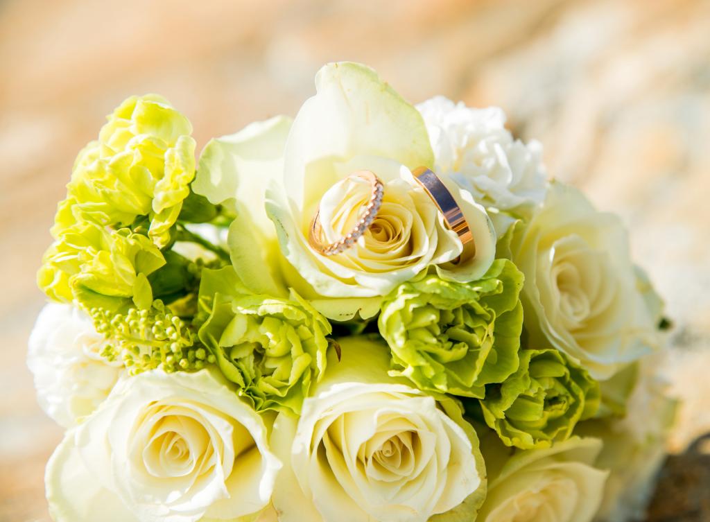 白玫瑰用康乃馨和结婚戒指的花束