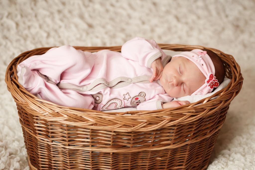 小可爱的小女孩在一个大篮子里睡觉