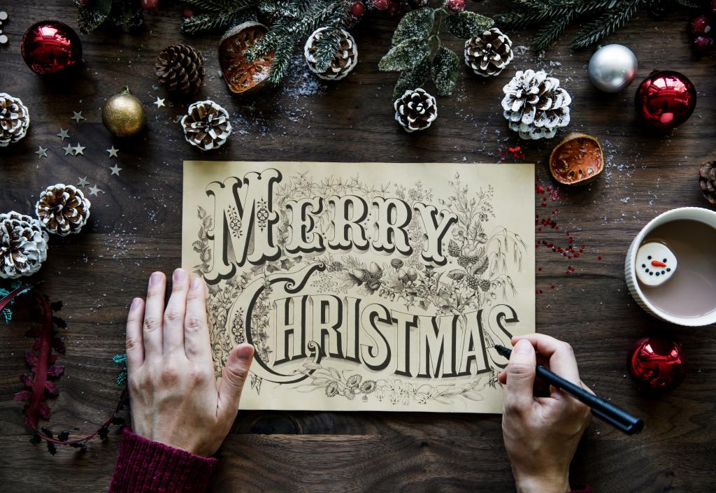 与题字圣诞快乐在圣诞节装饰的桌上的图画