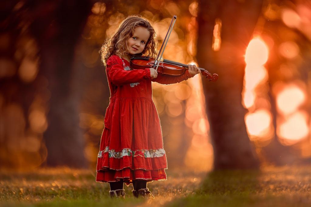 在她手中的小提琴红色连衣裙的小女孩