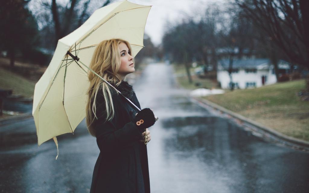 在一场雨下的白色雨伞下的金发女郎