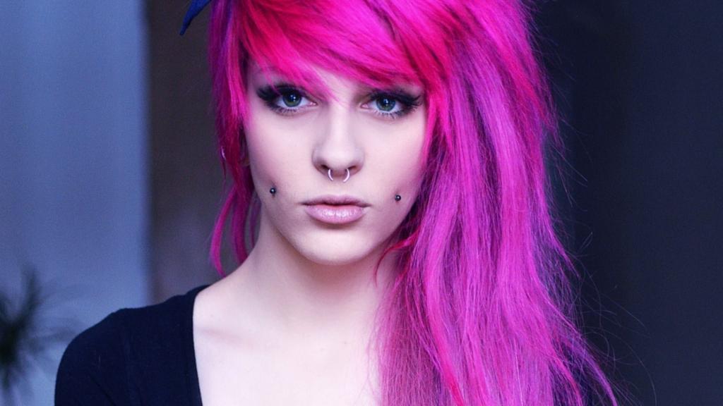 粉红色的头发和穿孔在她的脸颊的女孩