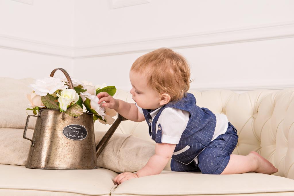 一个年幼的孩子在一个铁壶里检查花朵