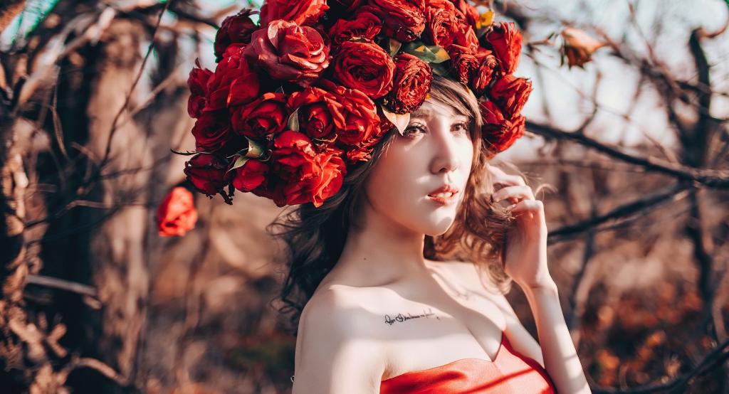 年轻的亚洲女孩，在她头上的红色花朵