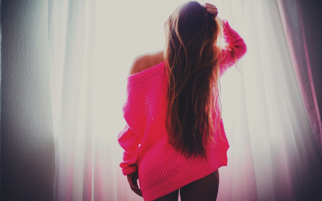 穿着粉红色夹克的黑发正站在窗边