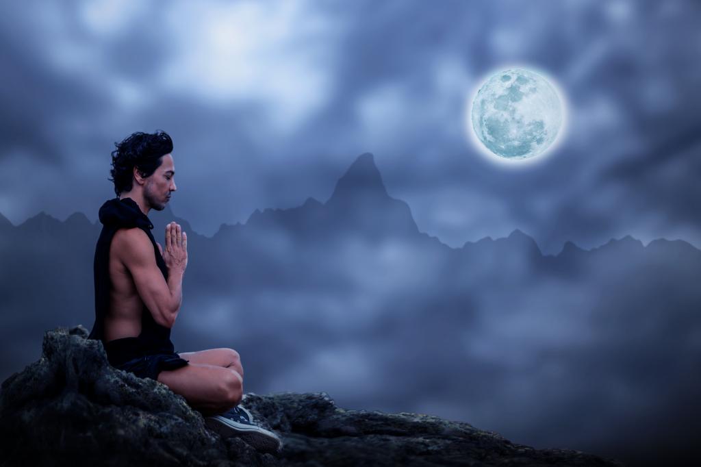 一个人在满月的夜晚在石头上冥想