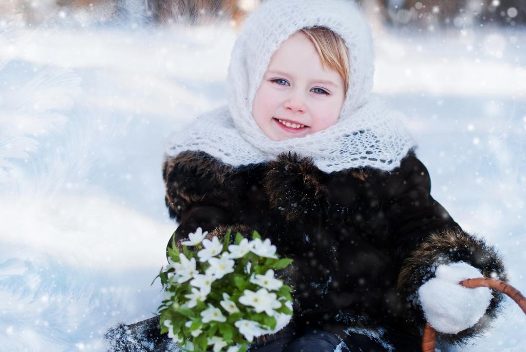 有一束雪花莲的小蓝眼睛的女孩在冬天