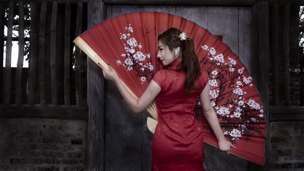 美丽的亚洲女孩穿着红色大风扇