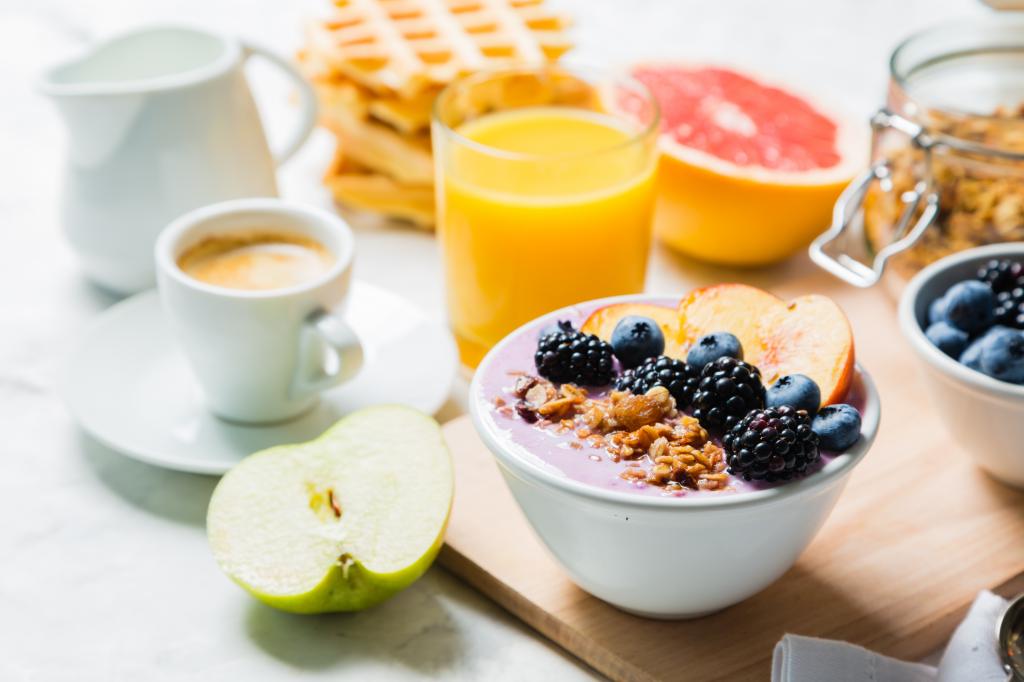早餐与燕麦，浆果，水果和新鲜果汁在桌子上