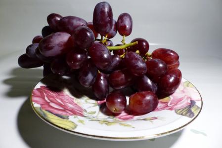 在盘子上的粉红葡萄关闭