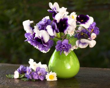 一束微妙的三色堇花和紫罗兰插在花瓶里