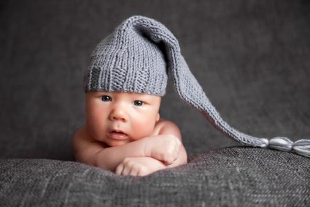 一个可爱的婴儿在一个大灰色针织帽子