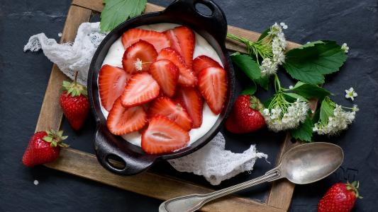 新鲜的草莓酸奶早餐在一张白色的桌子上的一张桌子