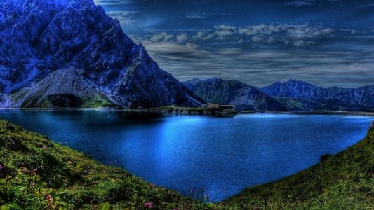 在黄昏的湖泊和山脉的蓝色水
