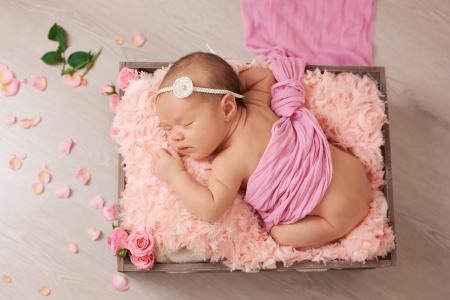 睡着的婴儿与粉红色的玫瑰花瓣