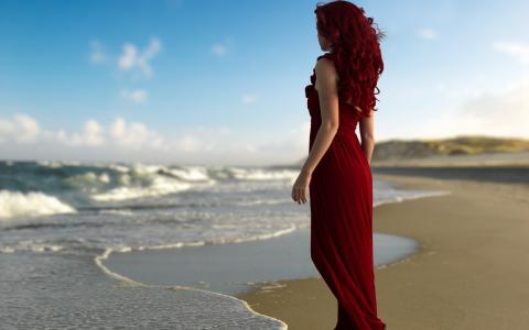 红头发，穿着红色在海滩上的女孩