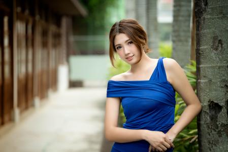 年轻的亚洲女孩穿着漂亮的蓝色连衣裙