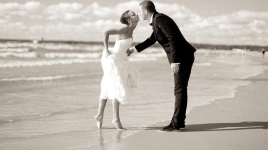 亲吻新娘和新郎在沙滩上