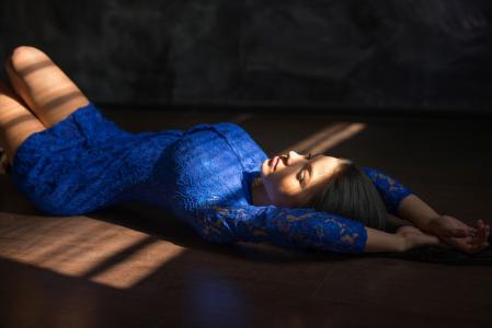 一件蓝色蕾丝礼服的女孩躺在地板上
