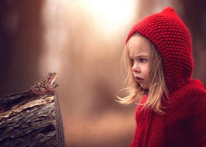 红色敞篷的惊讶的女孩看青蛙