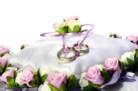 两个金结婚戒指坐垫上举行婚礼
