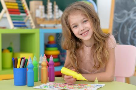 小女孩微笑着用铅笔绘制