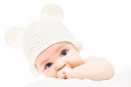 有一顶白色帽子和耳朵的蓝眼睛的婴孩在白色背景