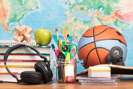 球，耳机，书籍和地图背景上桌上的文具