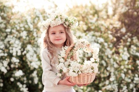 一个可爱的小女孩，头上戴着花环，一篮白花
