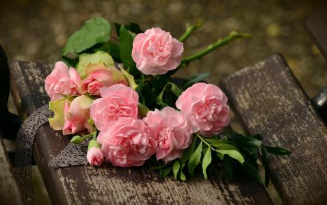 柔和的粉红色玫瑰花束在长凳上