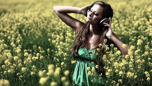 女孩站在耳机中的花朵之间