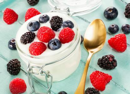 酸奶配新鲜树莓，蓝莓和黑莓在玻璃罐子里吃早饭