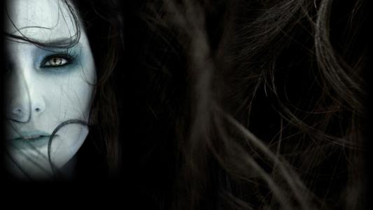 一个女孩在黑暗的背景上的头发中的脸