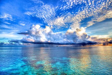 美丽的云彩反映在海洋的蓝色水中