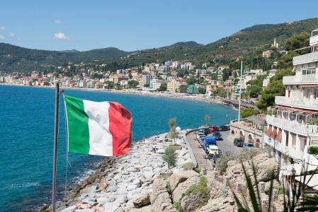 国旗在意大利阿拉西奥度假村海滩的背景