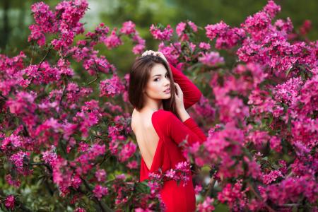 美丽的年轻女孩，穿着红色粉色的花背景上