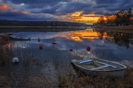 在一个安静的森林湖在日落时分的船
