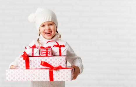 在一顶白色的帽子，笑着的女孩与圣诞礼物