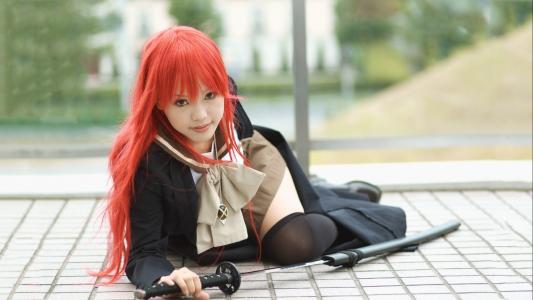红头发的日本女孩从刀鞘上拔出一把武士刀