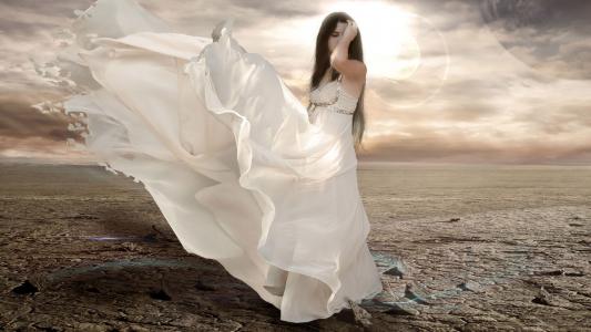 在沙漠中的白色连衣裙的女孩
