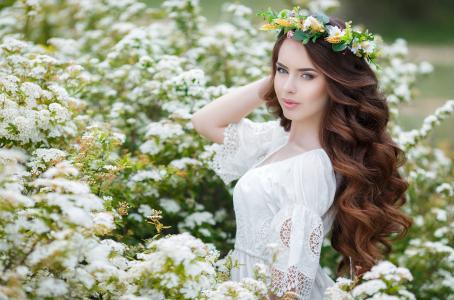 一个温柔的年轻女孩，穿着白色连衣裙与她头上的花环