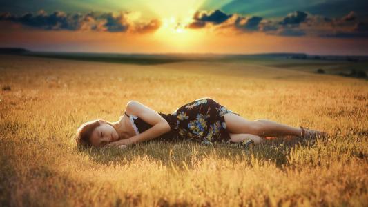 女孩躺在被割的田地上