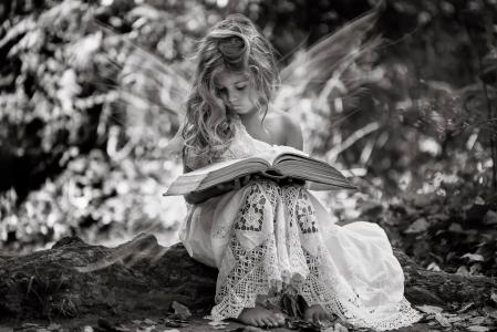 白色连衣裙与书，黑白照片的小女孩