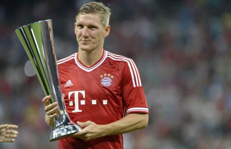 巴伐利亚中场Bastian Schweinsteiger拿着他的奖杯