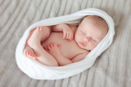 一个甜美的睡觉的婴儿在一个白色的面纱