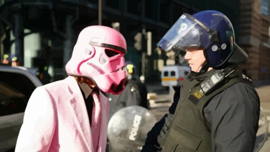 一名警察和一名男子在达斯·维达的粉红色面具