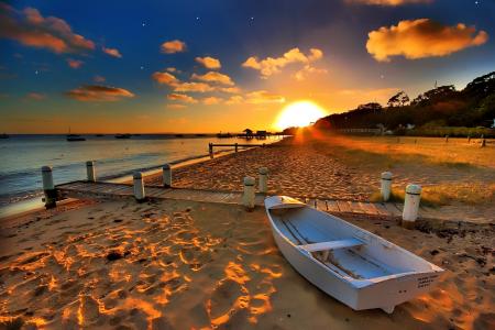 在夕阳下的海滩上的白色小船
